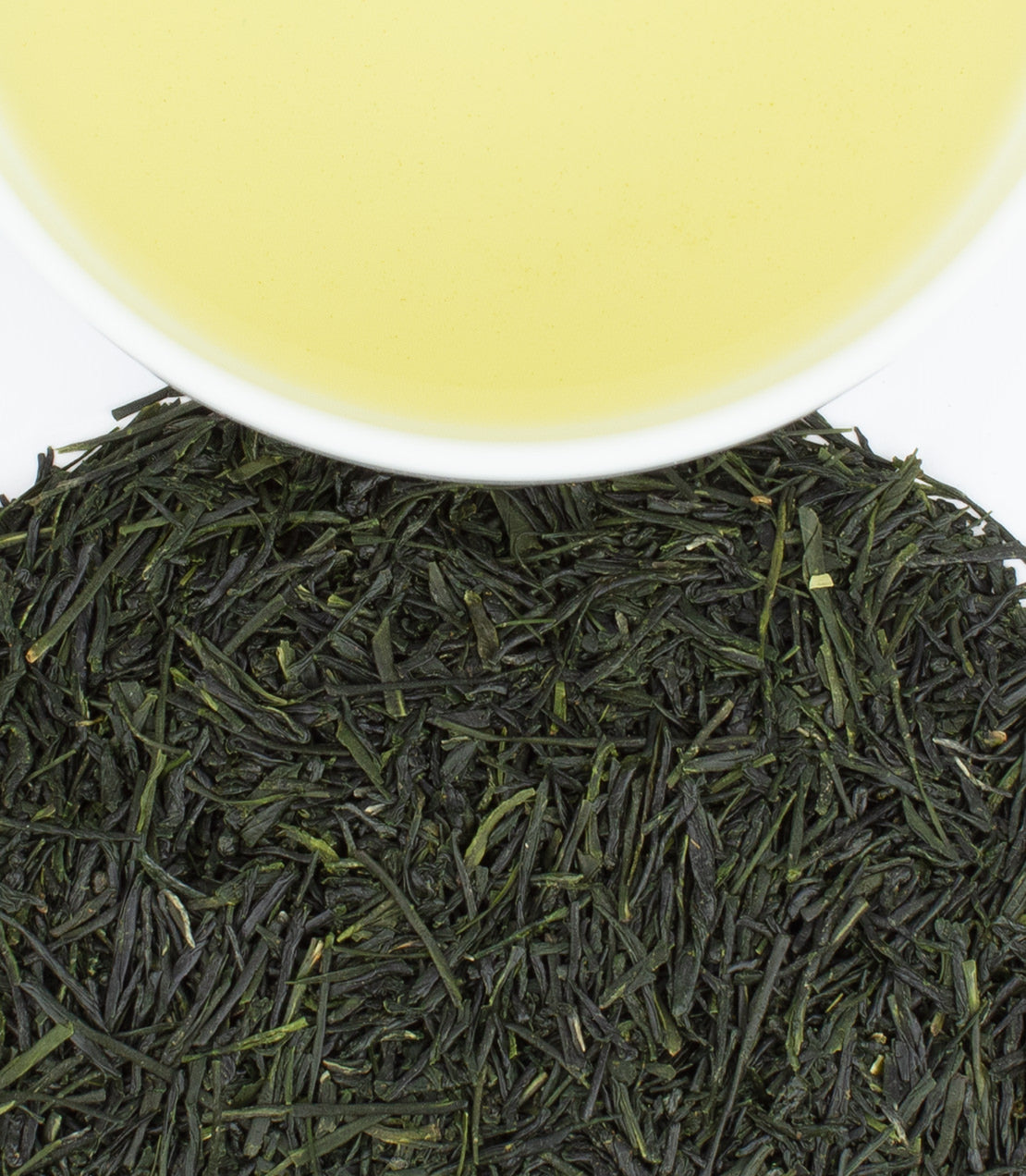 Fresh Asanoka Sencha green tea leaves with a cup of brewed tea, showcasing vibrant green color and rich texture.
