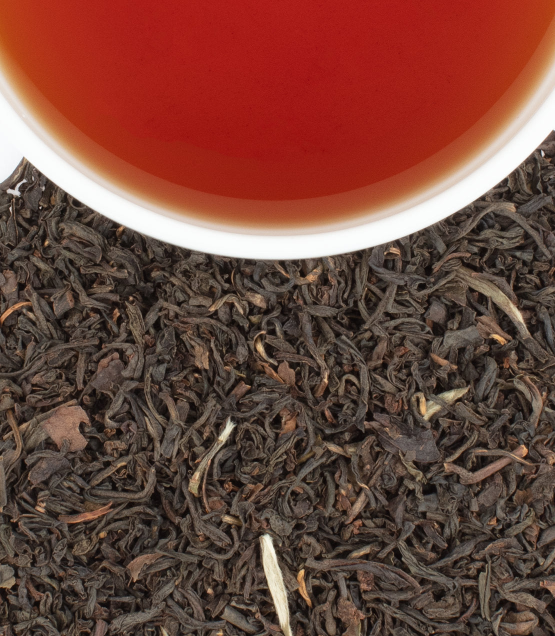Earl Grey Supreme tea sachets with a rich brew, surrounded by loose black tea leaves. Perfect for tea lovers.