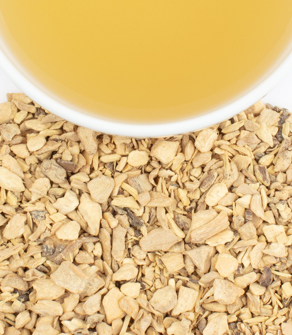 Ginger liquorice sachets with a cup of brewed tea above a bed of dried ginger pieces.