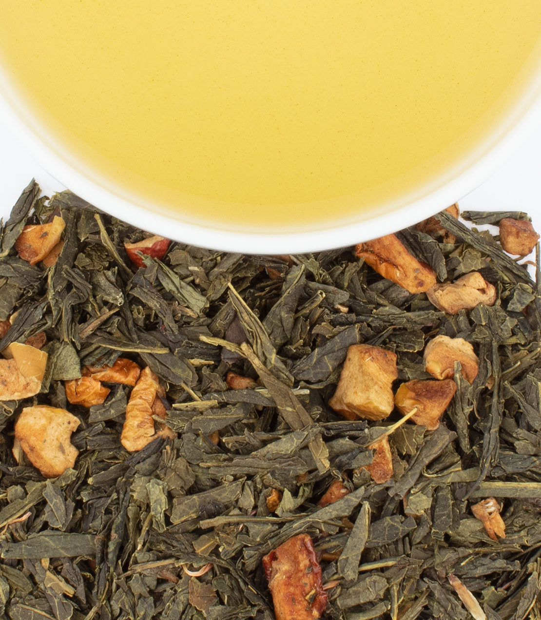 Little Women Orchard House Blend tea sachets with green tea and apple pieces, accompanied by a cup of brewed tea.