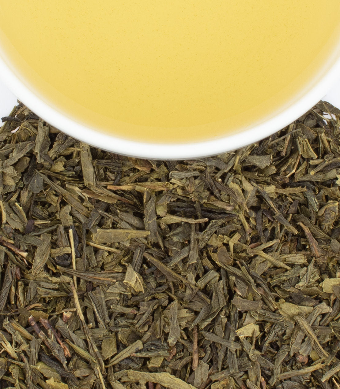 Brewed tea above loose green tea leaves.