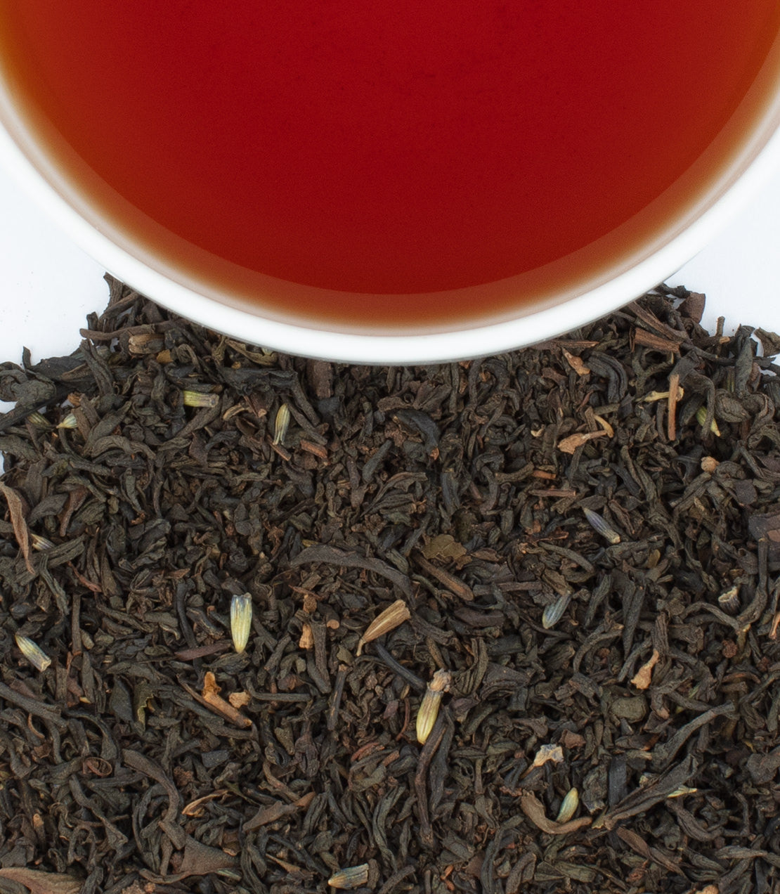 Victorian London Fog tea sachets in a tin, with brewed tea and loose tea leaves displayed.