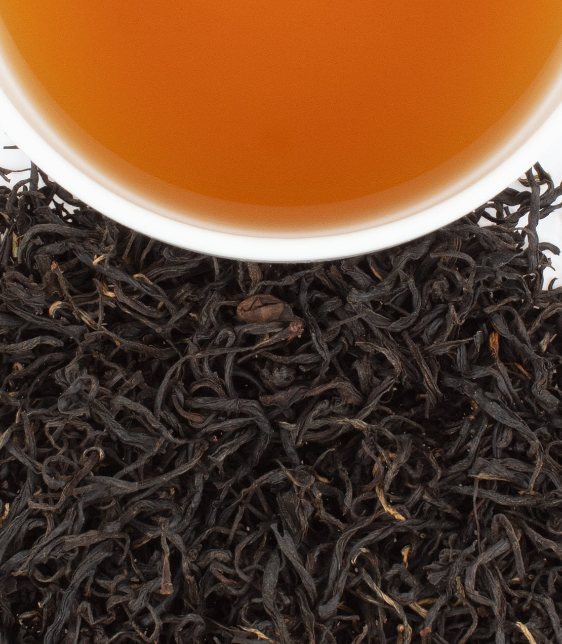 Chun’An Black tea leaves with a cup of brewed tea, showcasing rich color and texture.