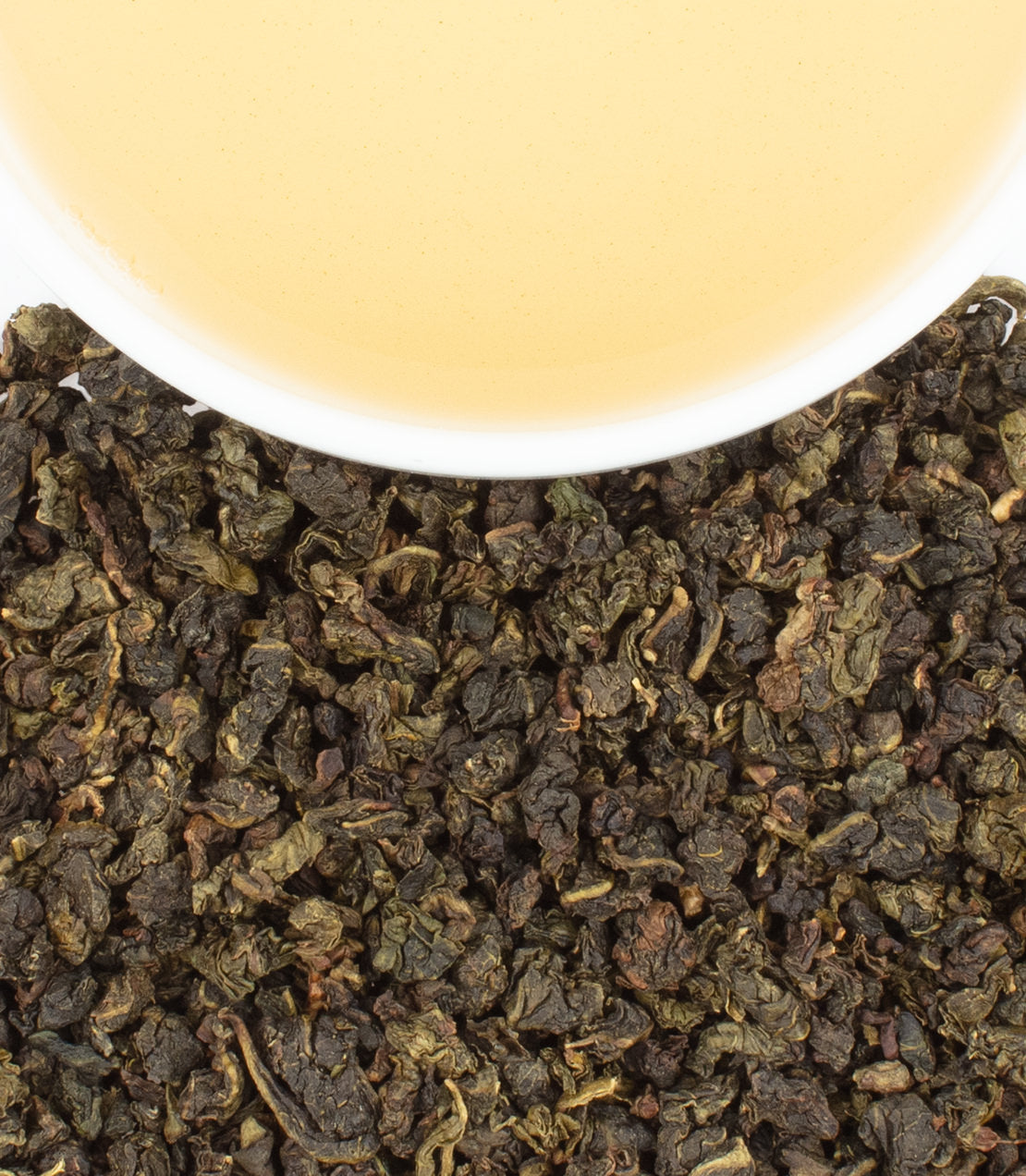 Coconut Lime Oolong tea leaves with a cup of brewed tea, showcasing rich colors and textures.