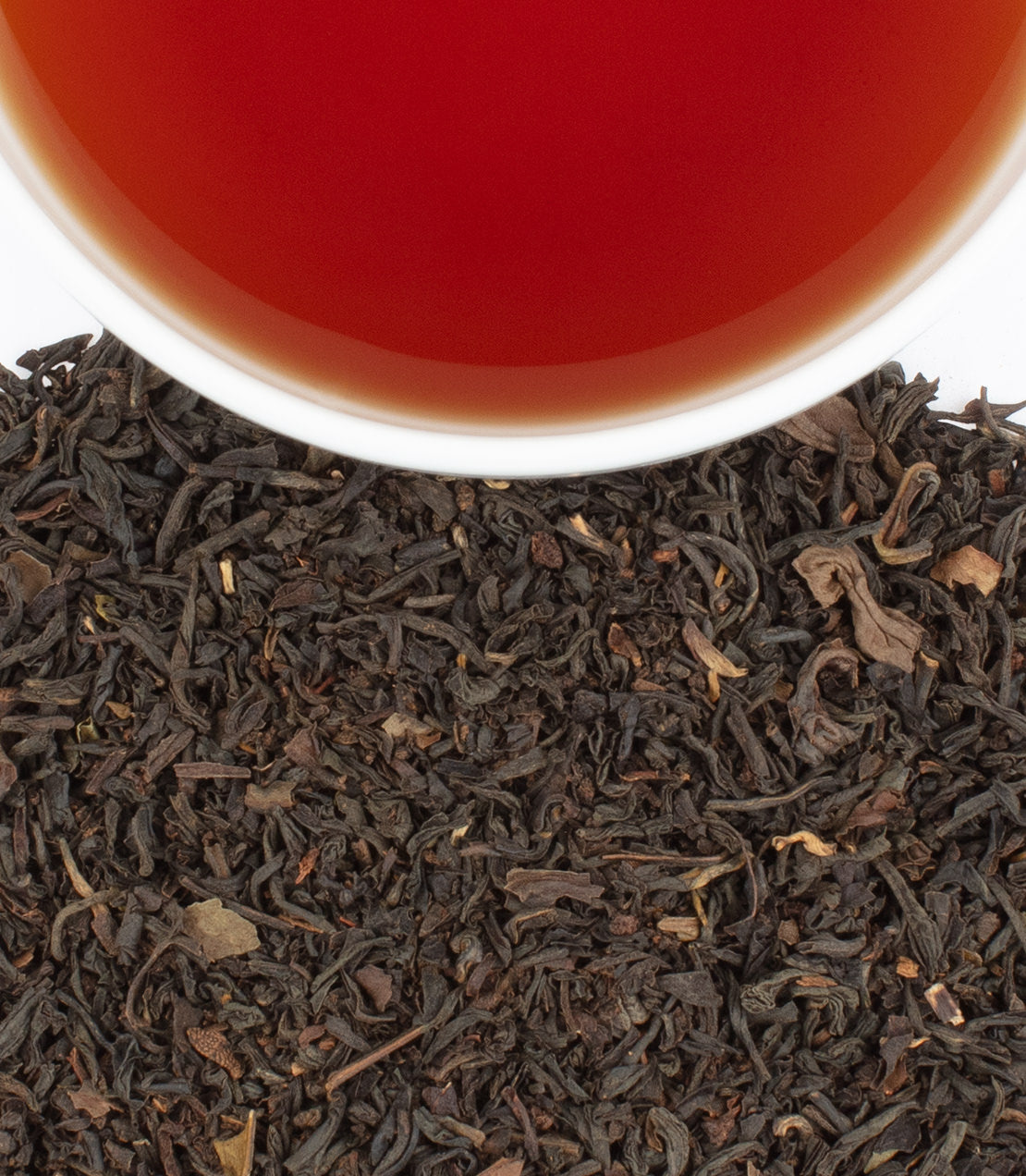 Williamsburg Earl Grey tea sachets with brewed tea in a cup, showcasing rich black tea leaves.