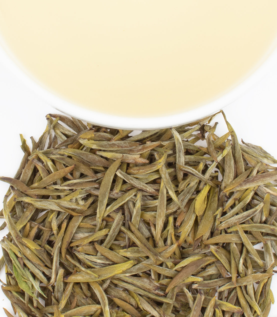 Junshan Yinzhen tea leaves with a cup of pale yellow brewed tea above, showcasing its delicate appearance.