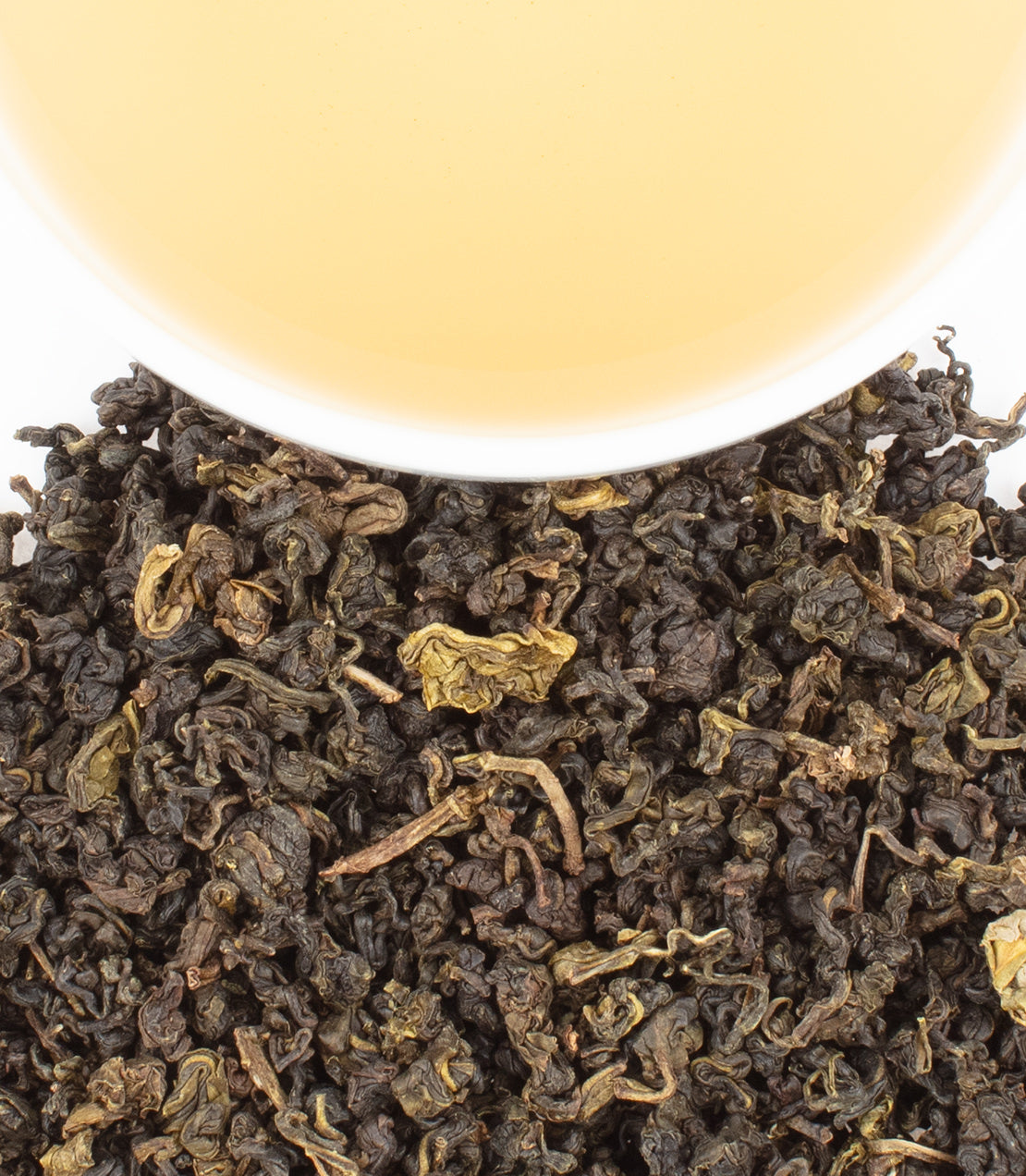 Close-up of Taiwanese Dan Cong tea leaves with a cup of brewed tea, showcasing rich colors and textures.
