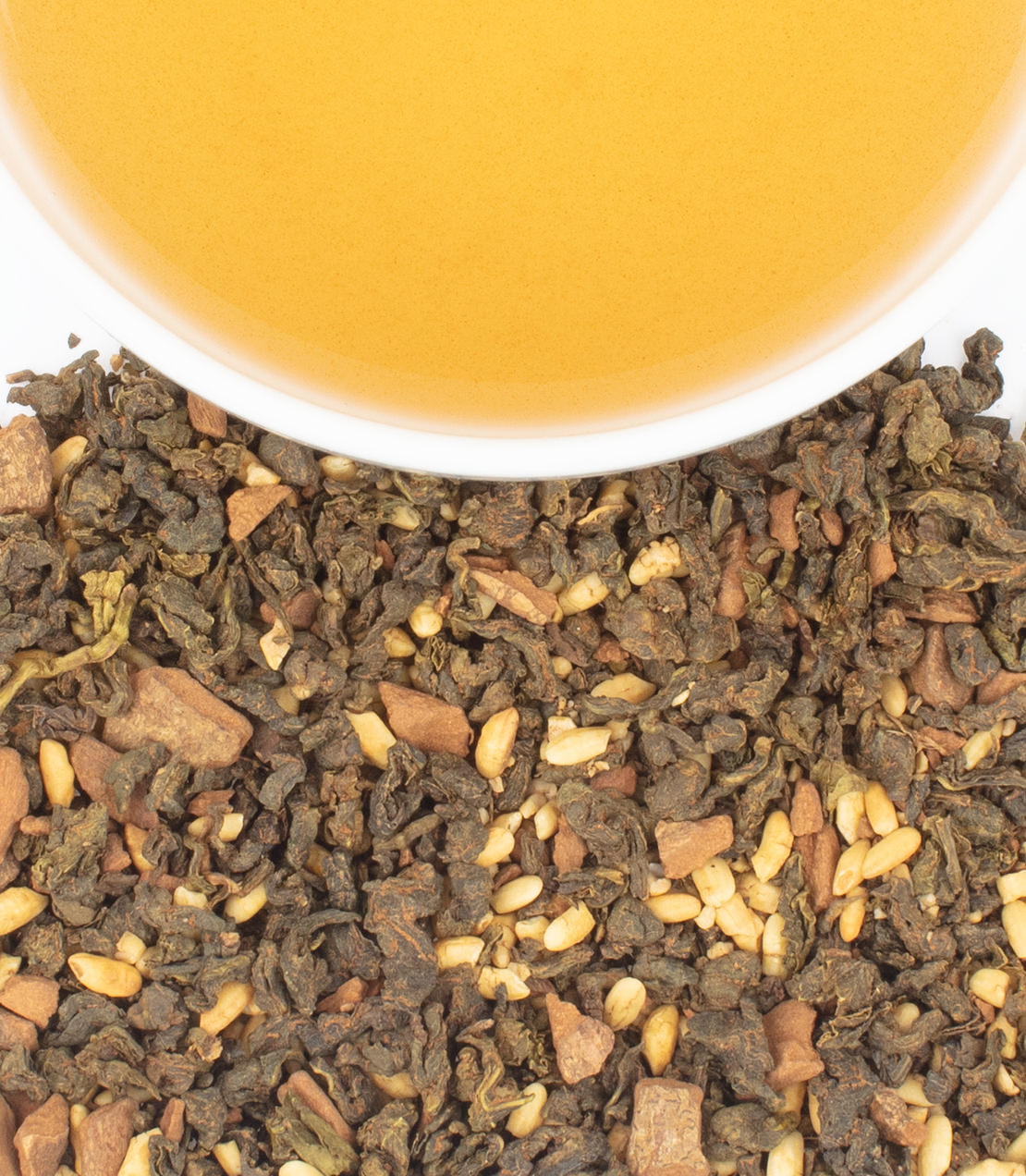 Horchata drink in a bowl above loose tea blend with spices and grains, showcasing HT Tin of 20 sachets.