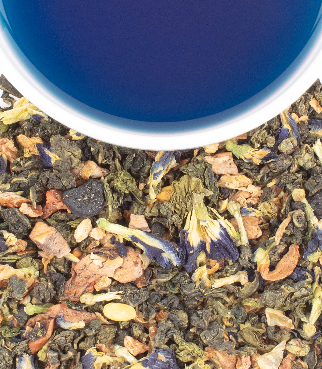 True Blue Oolong tea sachets with dried leaves and blue petals, beside a cup of brewed tea.