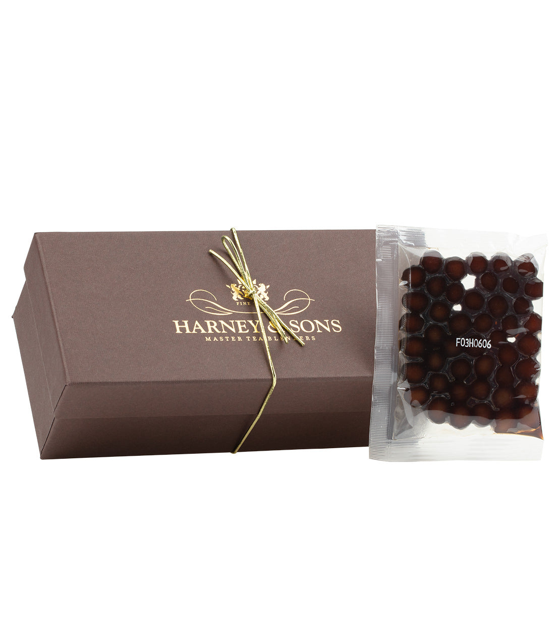 Harney & Sons tea package with brown box and clear bag filled with brown tapioca pearls on a white background