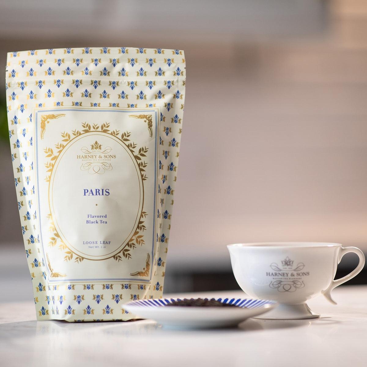 Paris 1 lb bag of loose tea on a marble kitchen counter with a dish of loose leaves and a white teacup