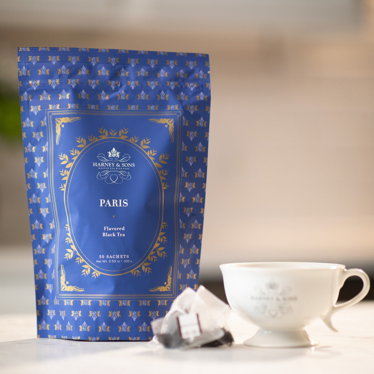 Paris Bag of 50 Sachets on a marble kitchen counter beside a tea sachet and a white teacup