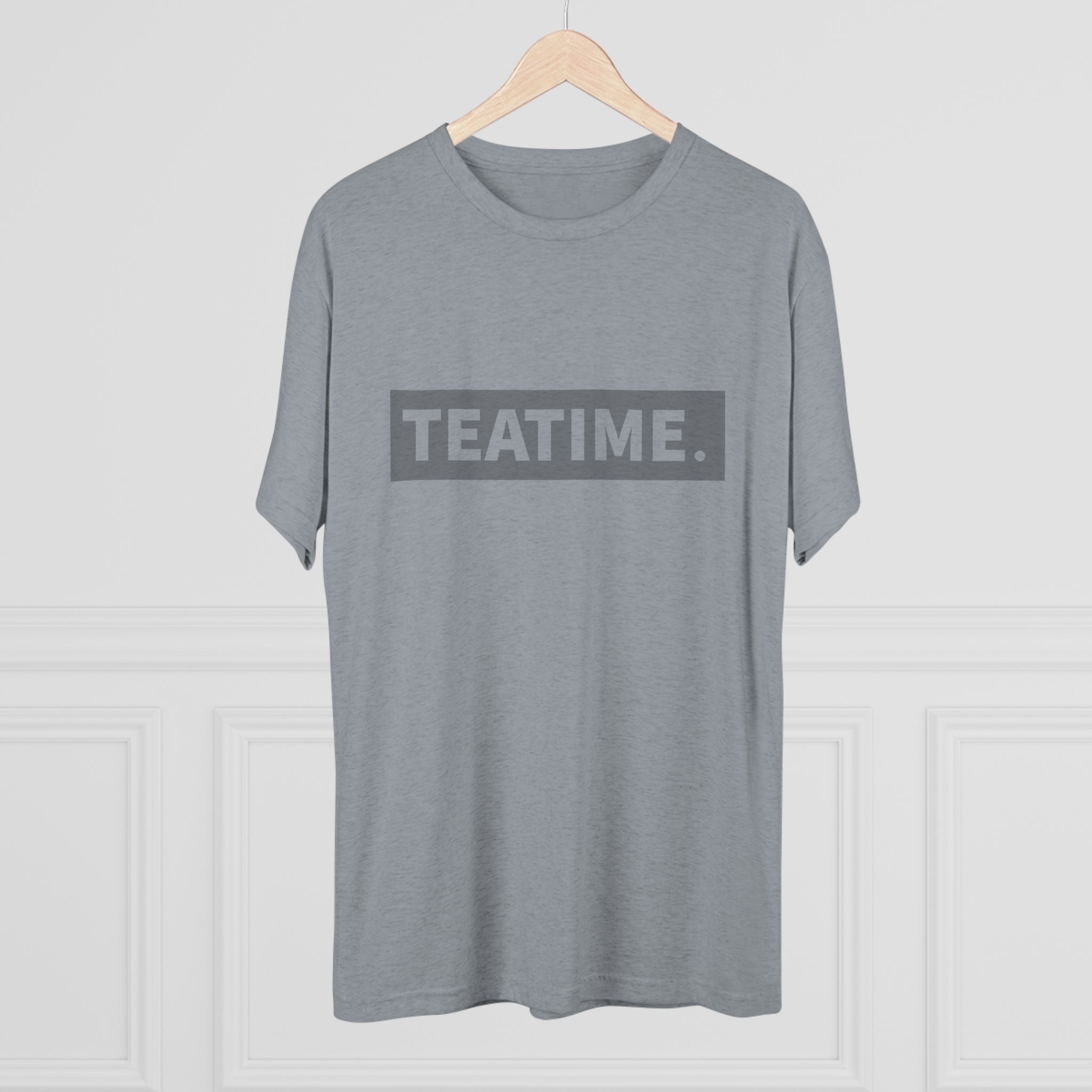 Gray graphic tee featuring the word "TEATIME." in bold black letters, displayed on a wooden hanger.