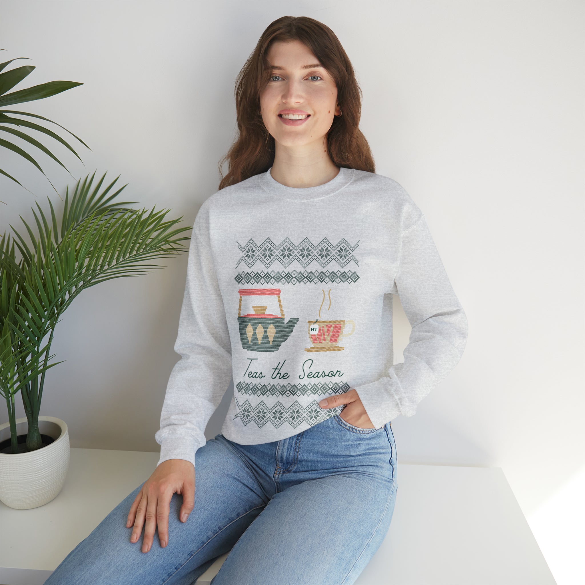 Cozy holiday sweater featuring "Teas The Season" graphic with tea cups and festive designs, perfect for winter.