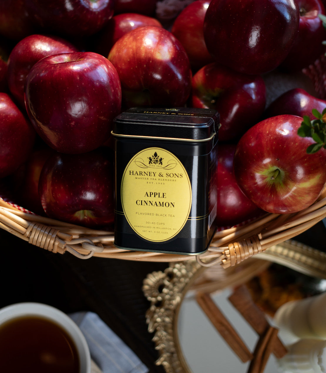 Harney & Sons Apple Cinnamon tea canister with red apples in a basket.