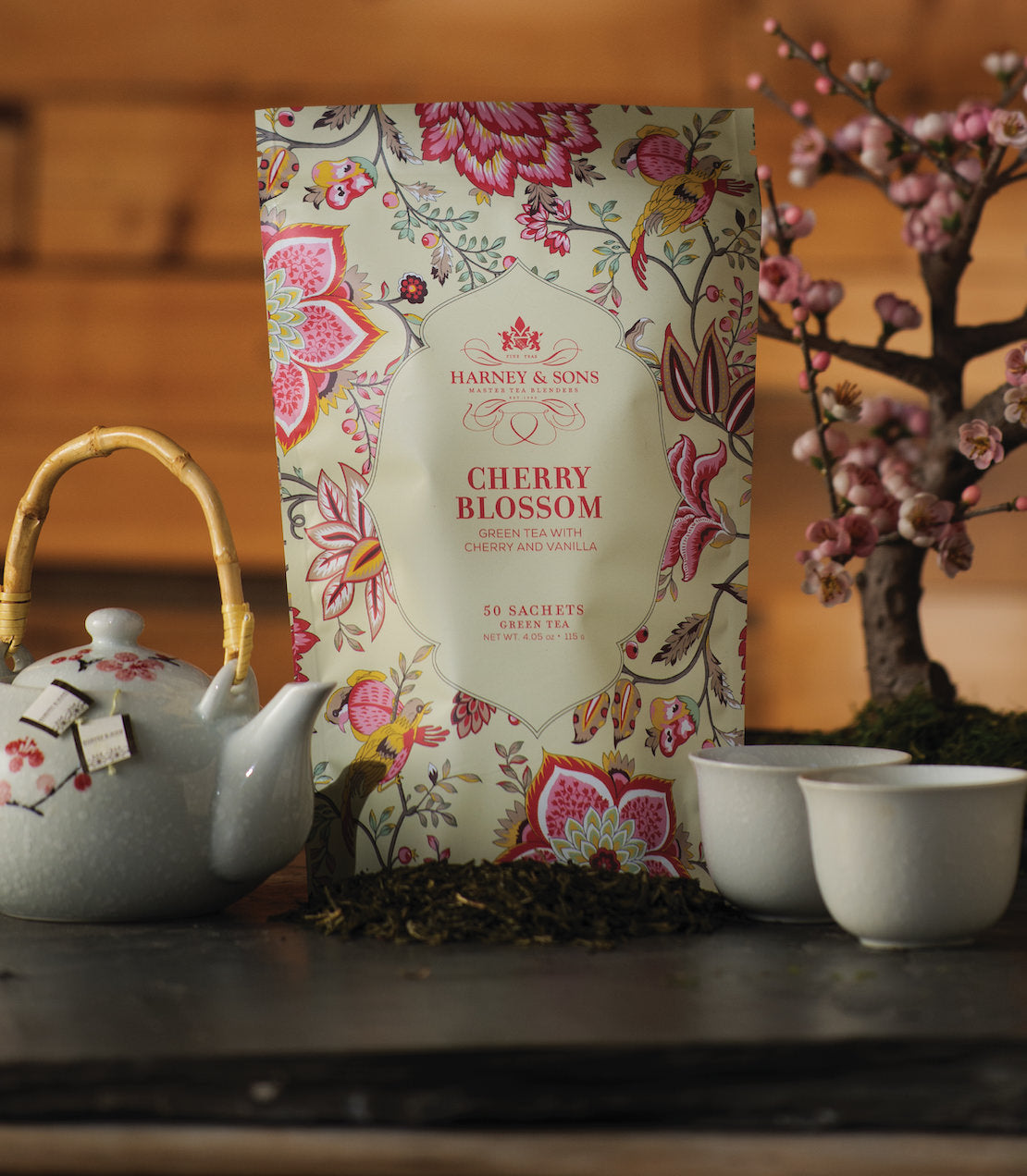"Harney & Sons Spring Bloom Trio featuring Cherry Blossom tea sachets, surrounded by a teapot and cherry blossom branches.