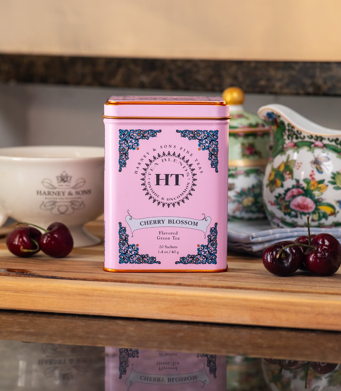 Cherry Blossom HT Tea tin with cherries on a wooden surface.