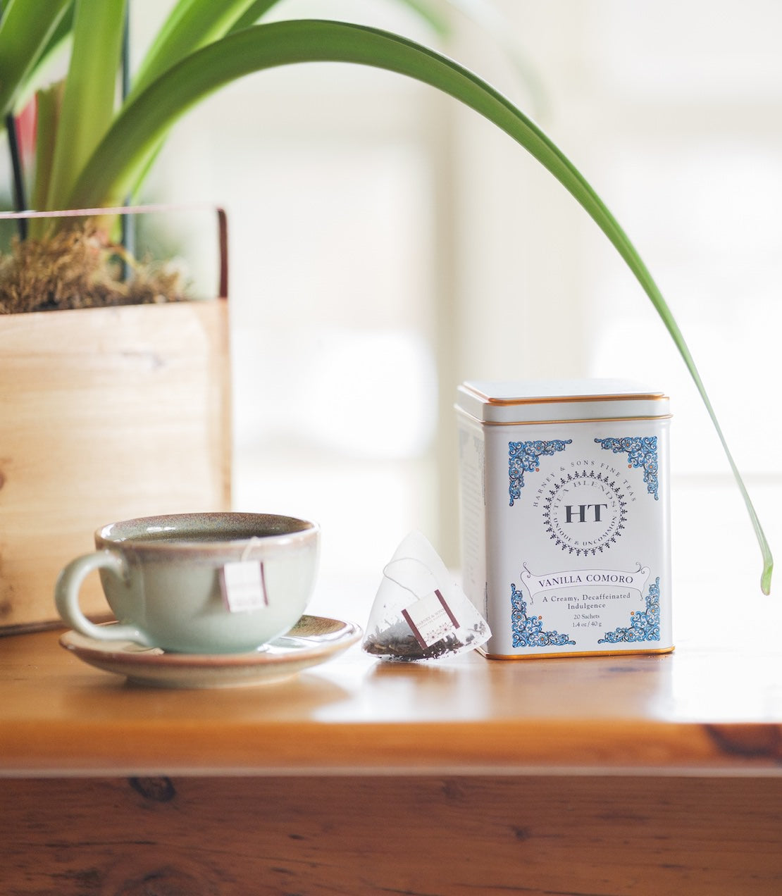 Decaf Vanilla Comoro tea tin with 20 sachets and a teacup and saucer.
