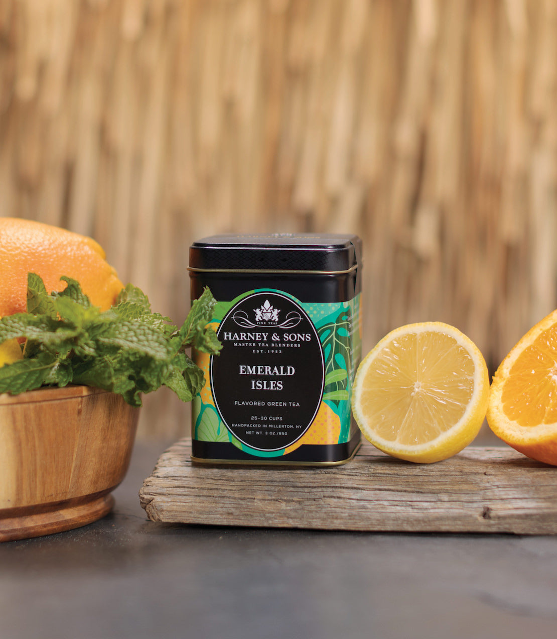 Harney & Sons Emerald Isles flavored iced tea tin beside fresh lemons and a wooden bowl, set against a natural backdrop.
