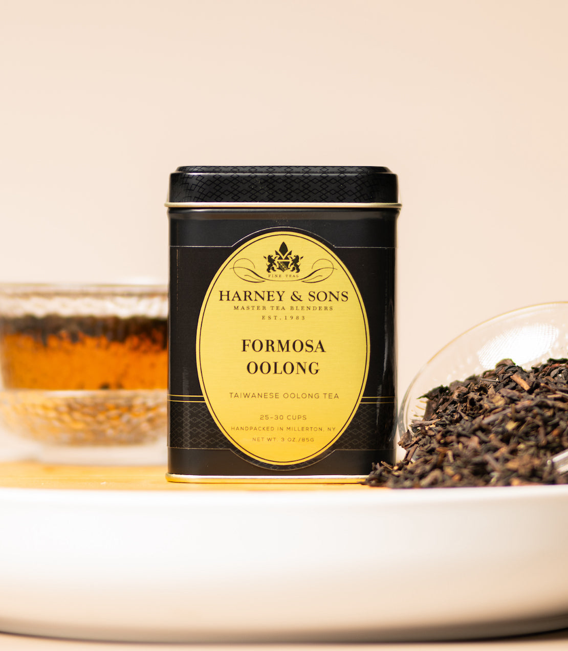 Tea canister with 'Harney & Sons Formosa Oolong' label, surrounded by tea leaves and a cup of tea.