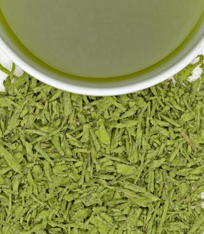 White Peach Matcha sachets, 50-count bag, with loose matcha leaves and a cup of brewed green tea.