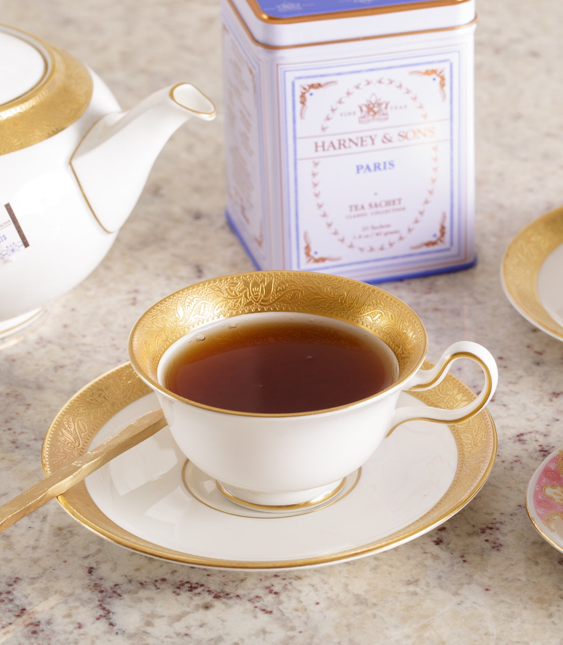 Harney & Sons Paris Classic tea tin with a teacup and saucer on a marble surface.