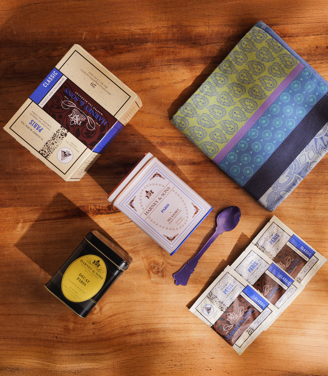 Collection of Paris tea products and accessories on a wooden surface.