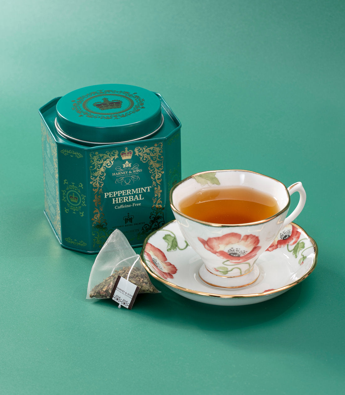 Peppermint herbal tea sachet steeping in a light green cup on a leaf, showcasing a refreshing beverage setup.