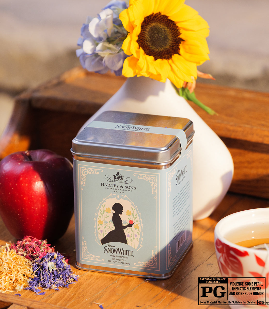 Tin of 20 Snow White tea sachets by Harney & Sons, featuring a silhouette design and surrounded by flowers and an apple.