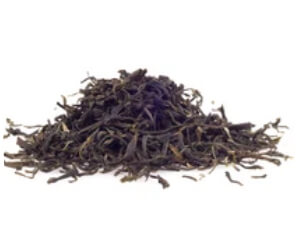 Loose black tea leaves, dark green and brown, piled in a small heap, perfect for tea enthusiasts and connoisseurs.