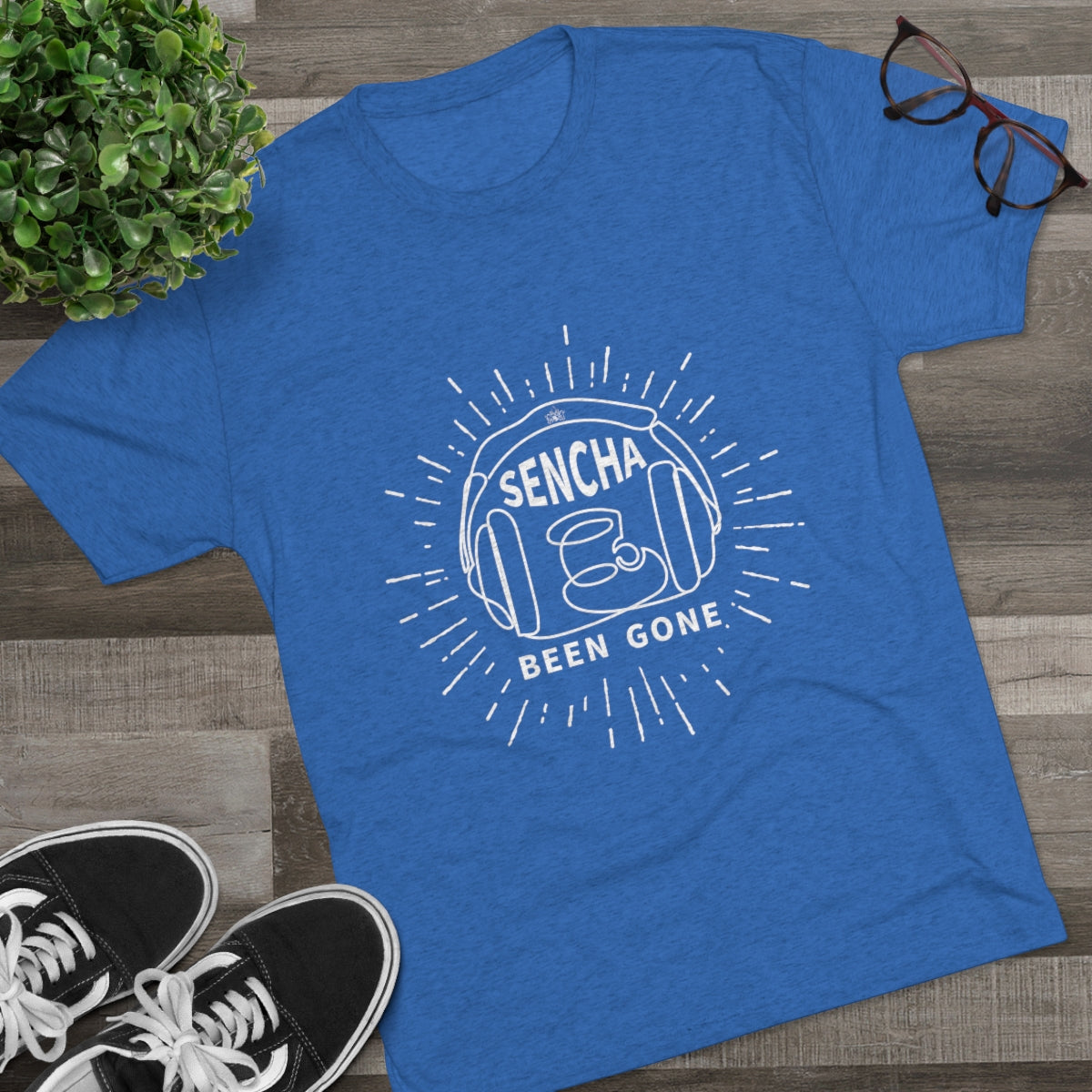 Blue graphic tee featuring "Sencha Been Gone" design with a teacup and sunburst, styled with sneakers and glasses.