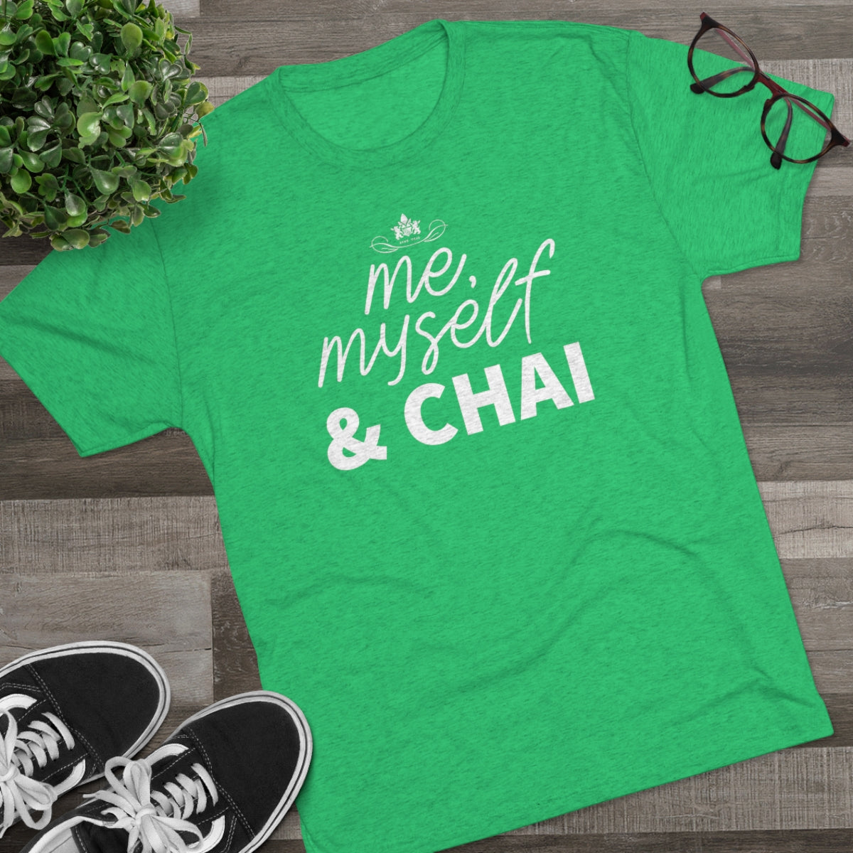 Green graphic tee featuring the text "me, myself & CHAI" in bold white letters, styled for casual wear.