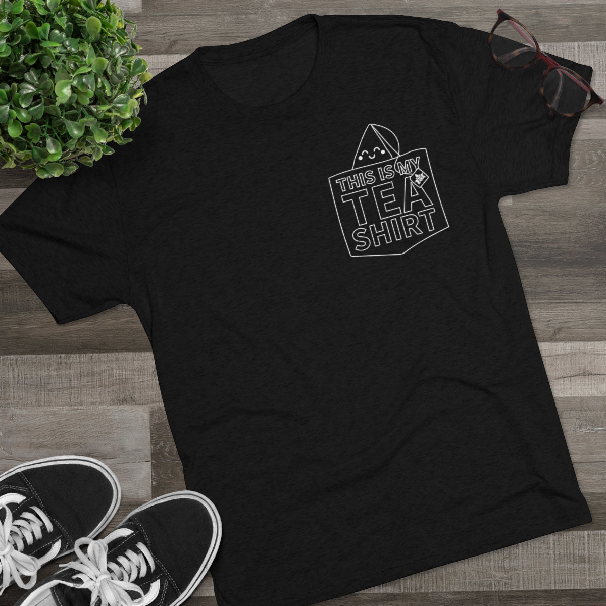 Black graphic tee featuring the text "This Is My Tea Shirt" with a tea bag design, styled with casual accessories.