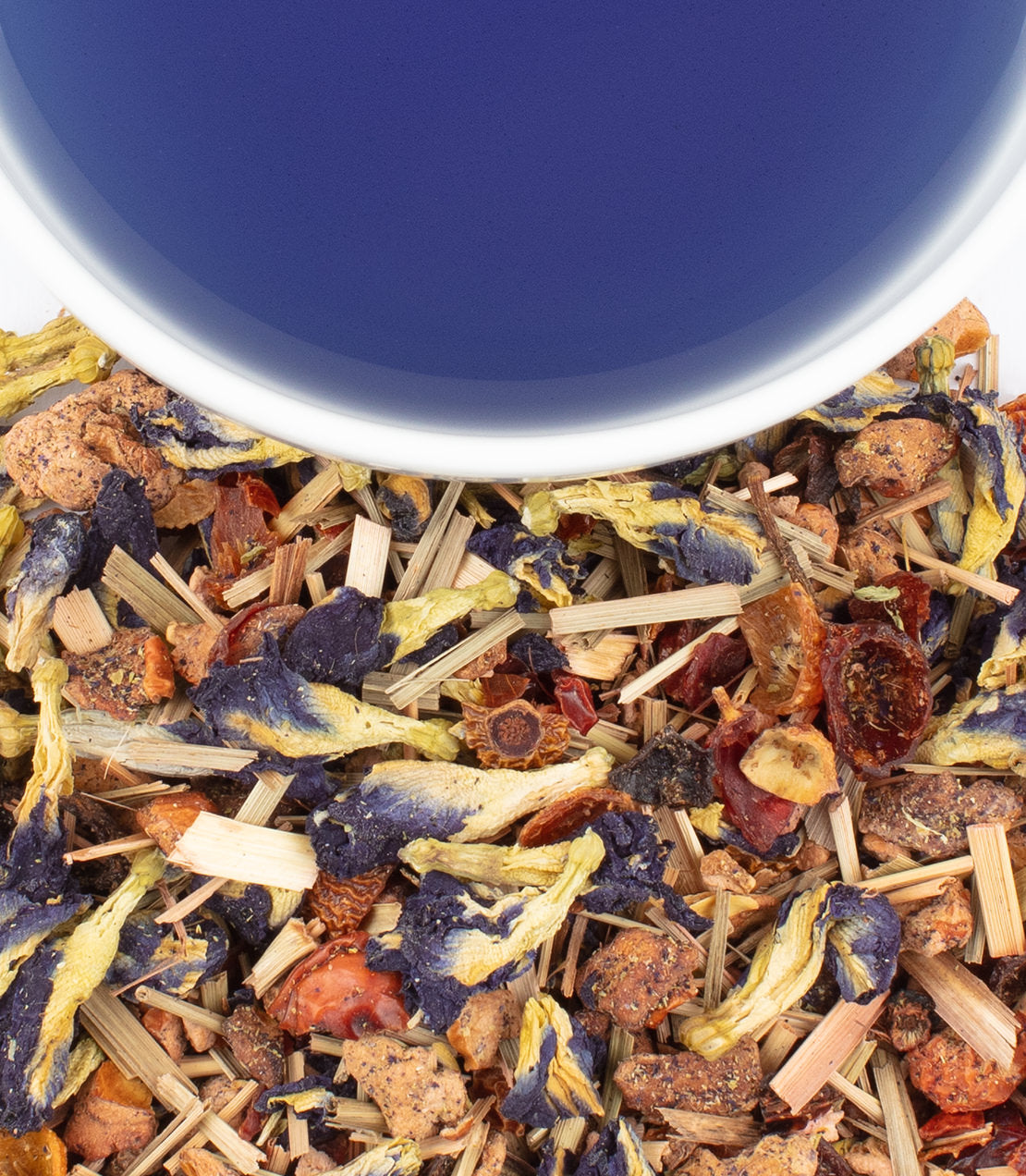 Vibrant Indigo Punch tea blend with dried herbs and flowers, alongside a cup of deep blue tea.