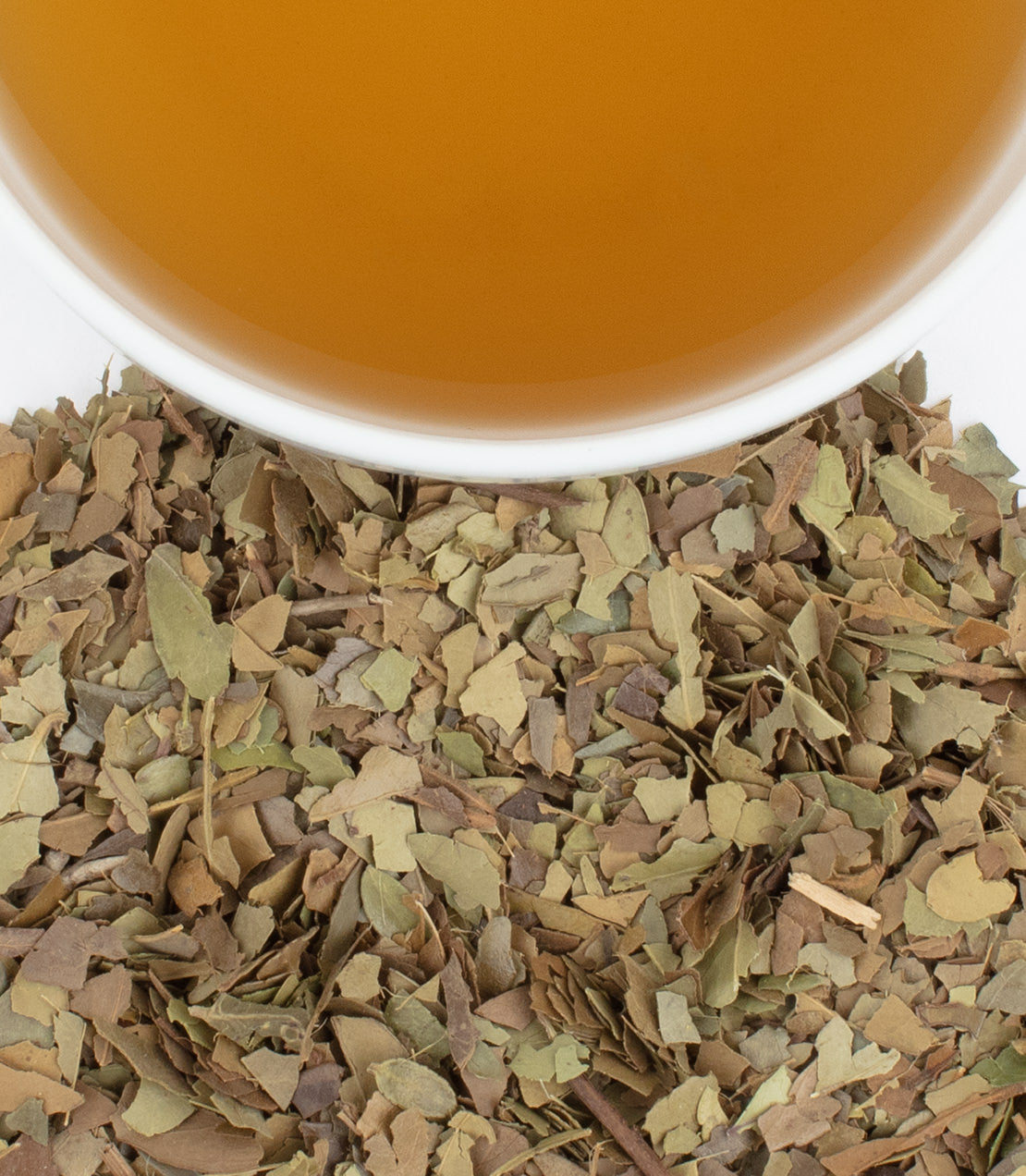 Dried Yaupon leaves beside a cup of brewed Yaupon Black tea, showcasing its earthy tones and texture.