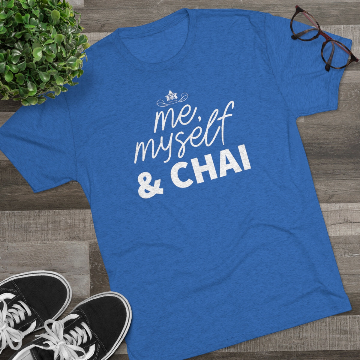 Blue graphic tee featuring the text "me, myself & CHAI" in white, paired with black sneakers and glasses.