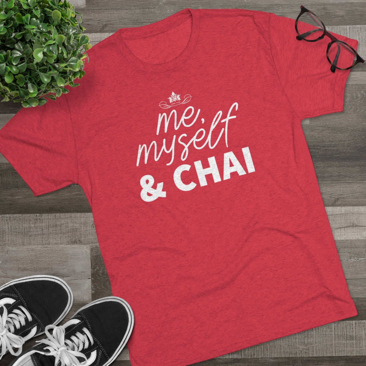 Red graphic tee featuring the text "me, myself & CHAI" in a playful font, styled with glasses and sneakers.