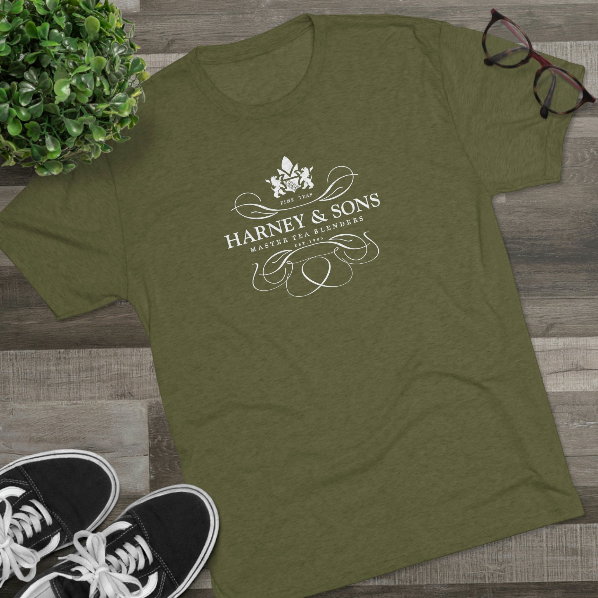 Olive green graphic tee featuring the Harney & Sons logo with elegant design elements. Perfect for tea lovers.