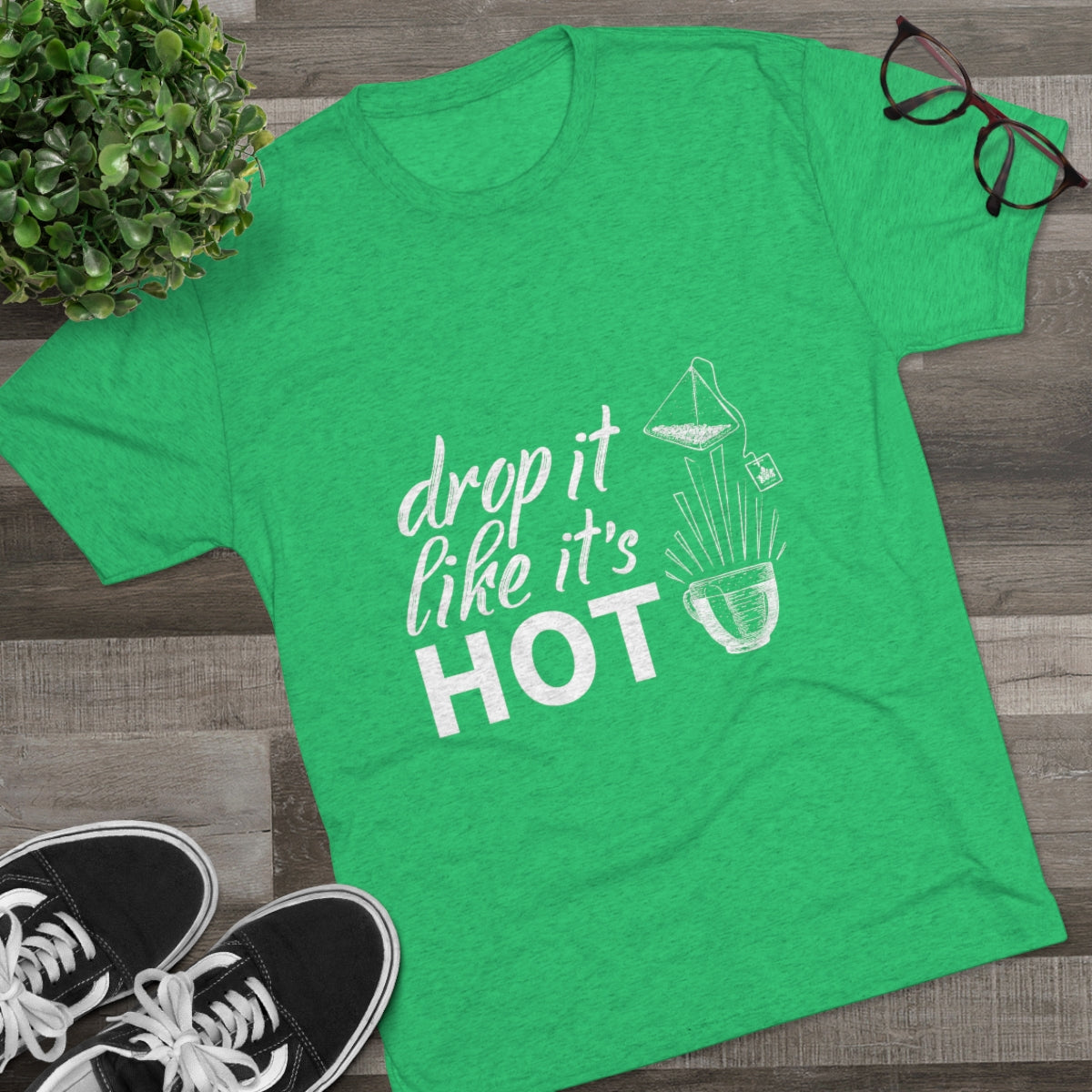 Green graphic tee featuring the phrase "drop it like it's HOT" with a playful design of a bowl and ingredients.