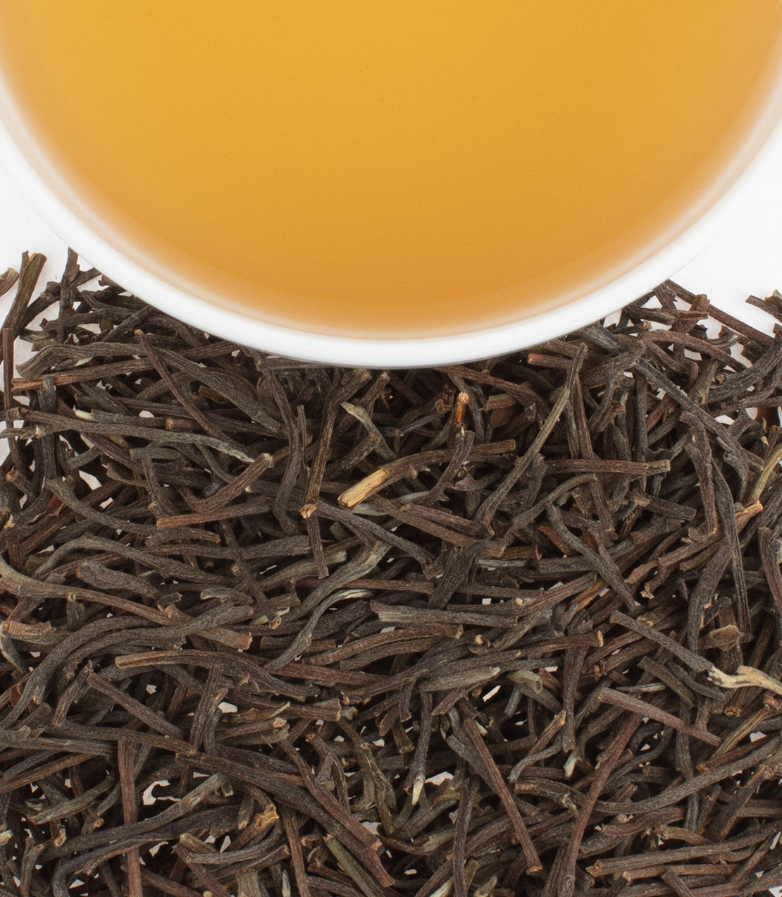 A close-up of African antlers displayed alongside a cup of light amber tea, highlighting their unique texture.