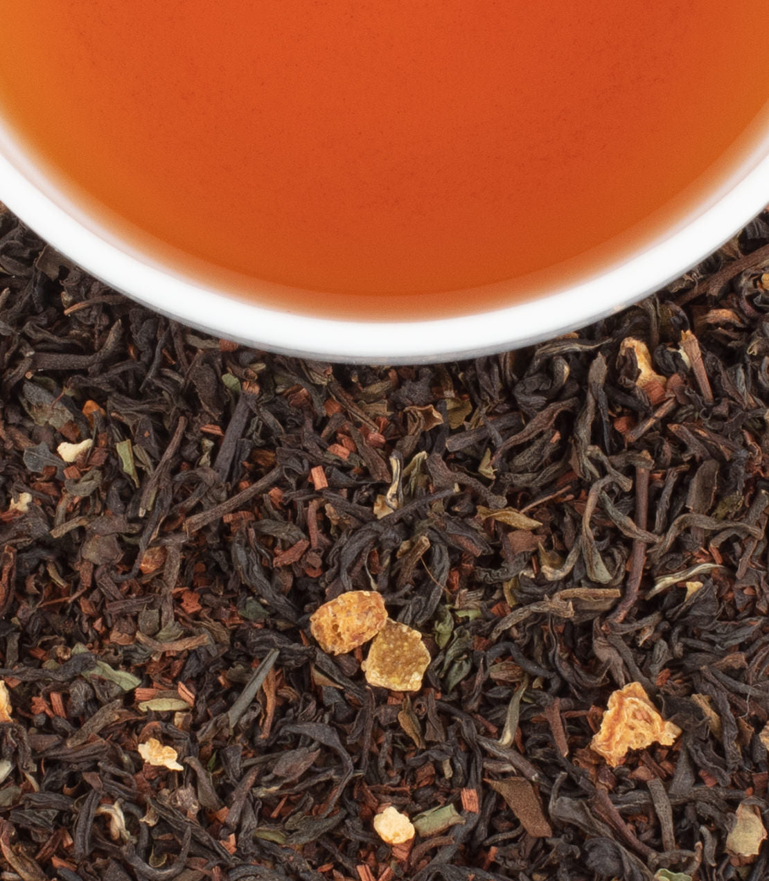 A close-up of Dar-Jee-Lingside tea leaves with a cup of brewed tea, showcasing rich colors and textures.