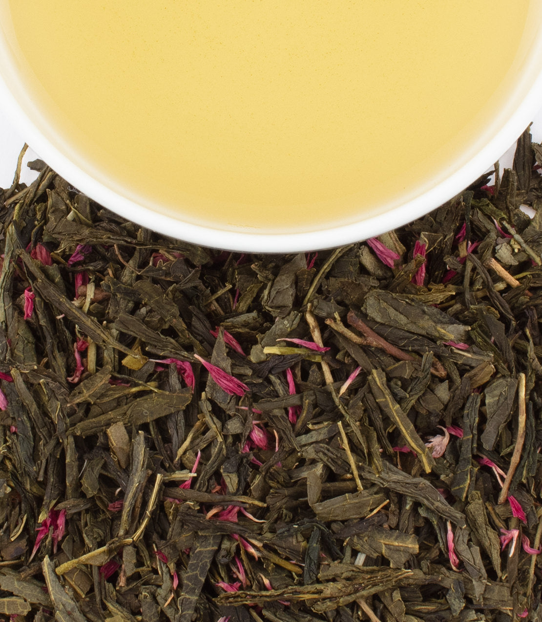 "Love Life tea sachets with green tea leaves and rose petals beside a cup of brewed tea.