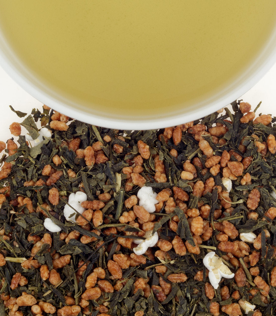 Genmaicha tea sachets with roasted rice, brewed green tea in a cup above, showcasing a unique blend.
