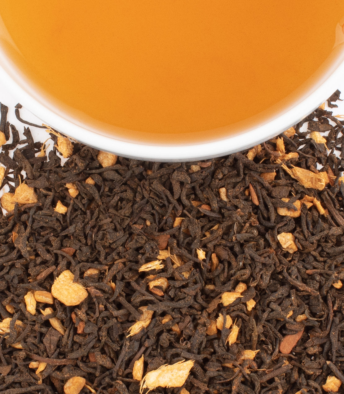 Gingerbread Festival tea with black tea leaves and spices, featuring a cup of brewed tea above.