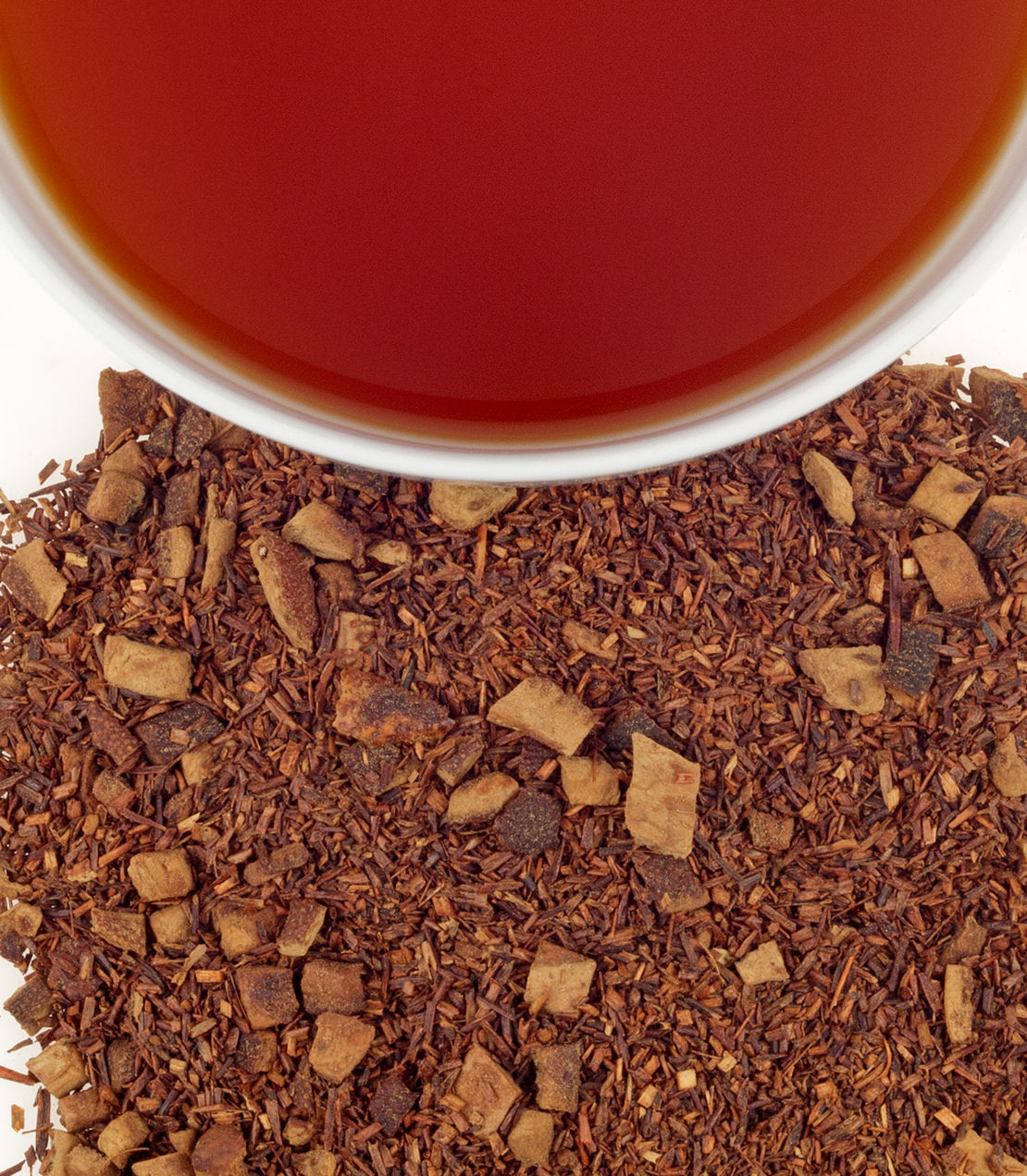 Herbal Hot Cinnamon Spice tea sachets with loose tea blend and brewed tea in a cup above.
