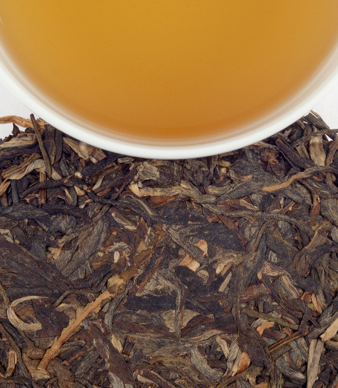 Lao Ban Zhang Pu-Erh tea leaves with brewed tea in a cup, showcasing rich colors and textures.