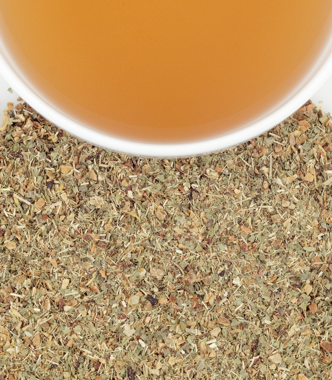A close-up of dried lemon herbal tea leaves with a cup of brewed tea above, showcasing earthy tones and textures.