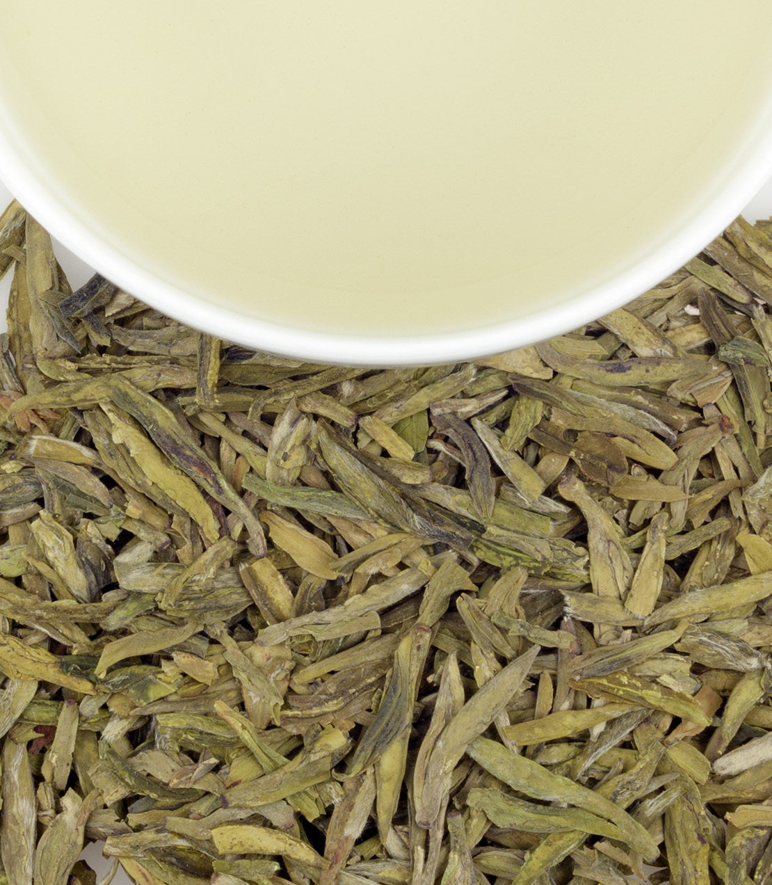 Lung Ching green tea sachets with brewed tea in a cup, showcasing loose leaves and vibrant color.