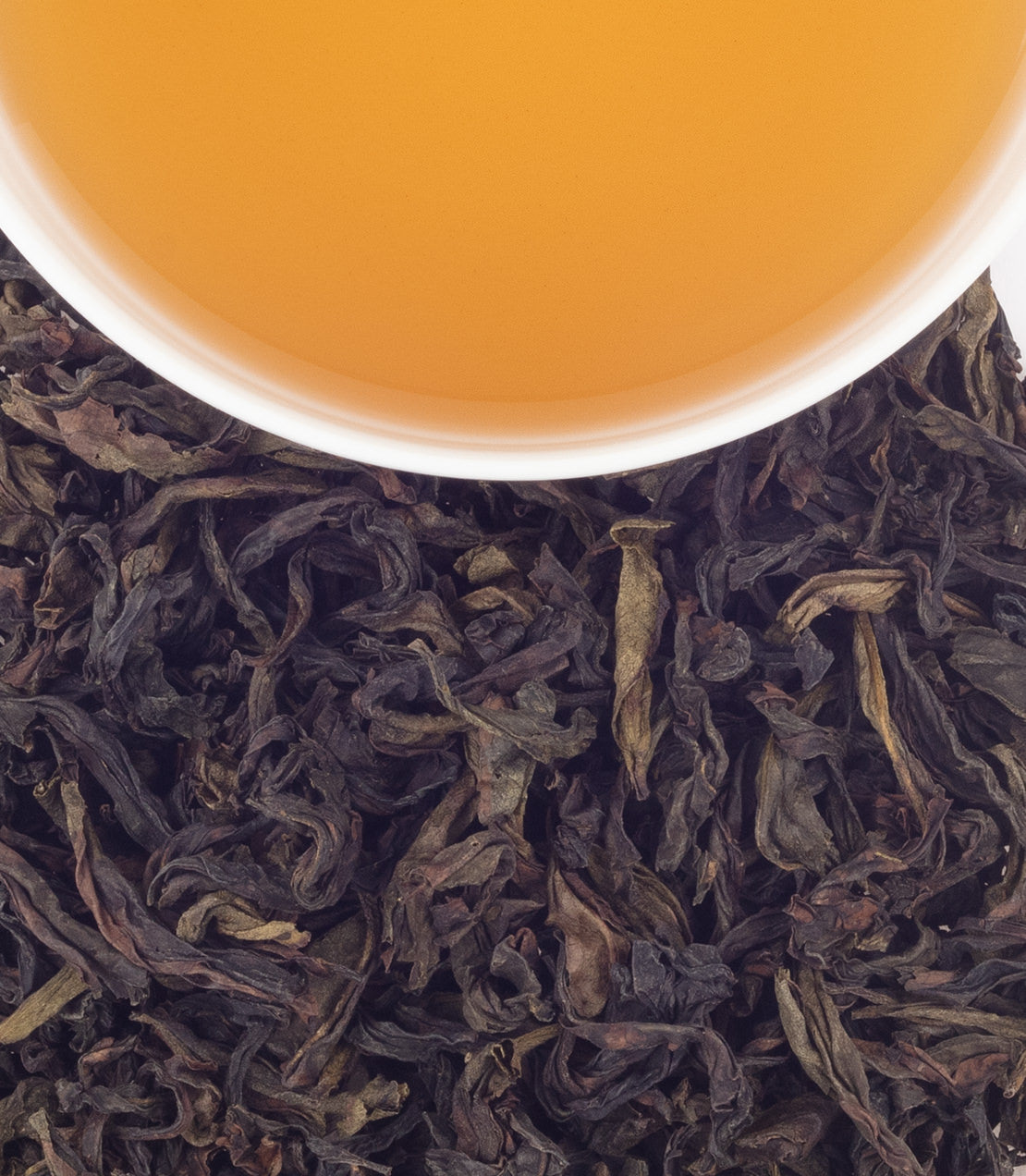 Aromatic 1,000 Miles Aroma Oolong tea leaves with a cup of brewed tea above, showcasing rich color and texture.