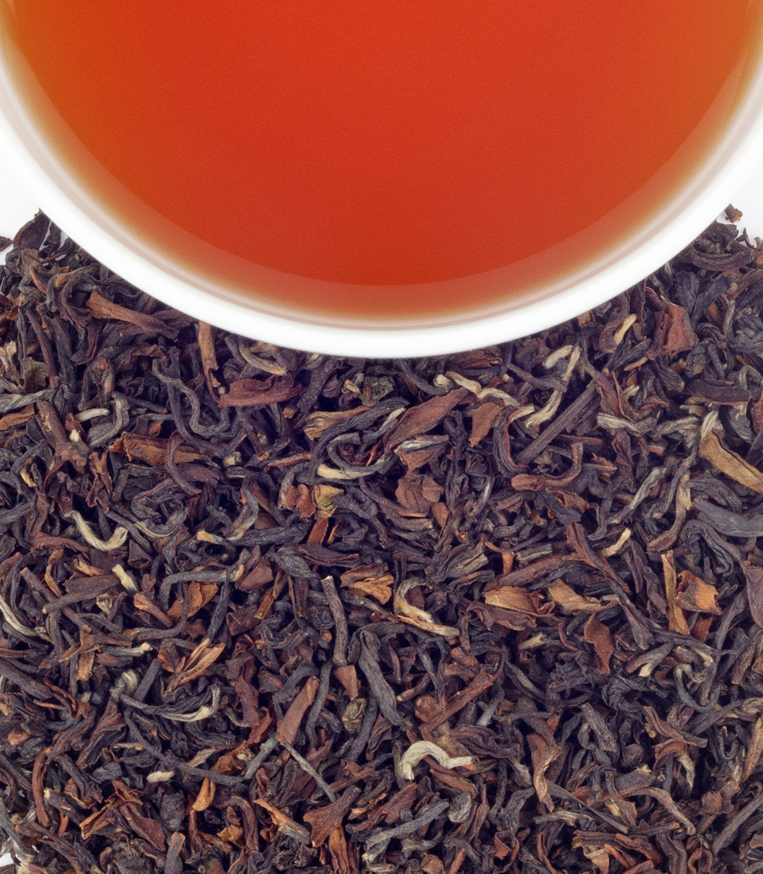 Close-up of Singell 2nd Flush tea leaves with a cup of brewed tea, showcasing rich color and texture.